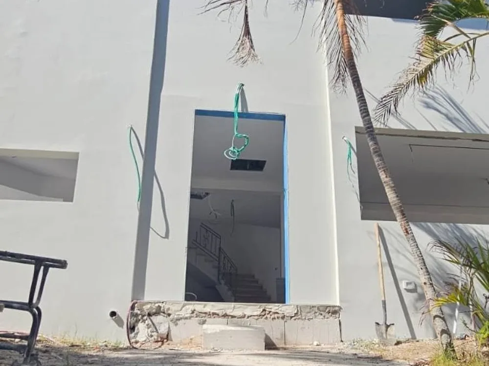 חזית בית פרטי לבן עם חלונות כהים בזמן עבודות השיפוץ