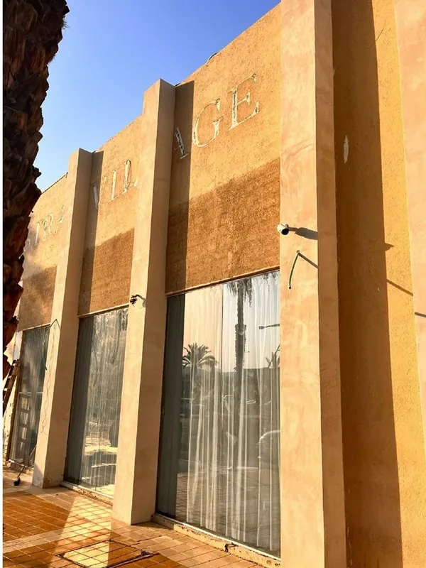 חזית המלון לפני החידוש: טיח כתום דהוי ושלט ישן