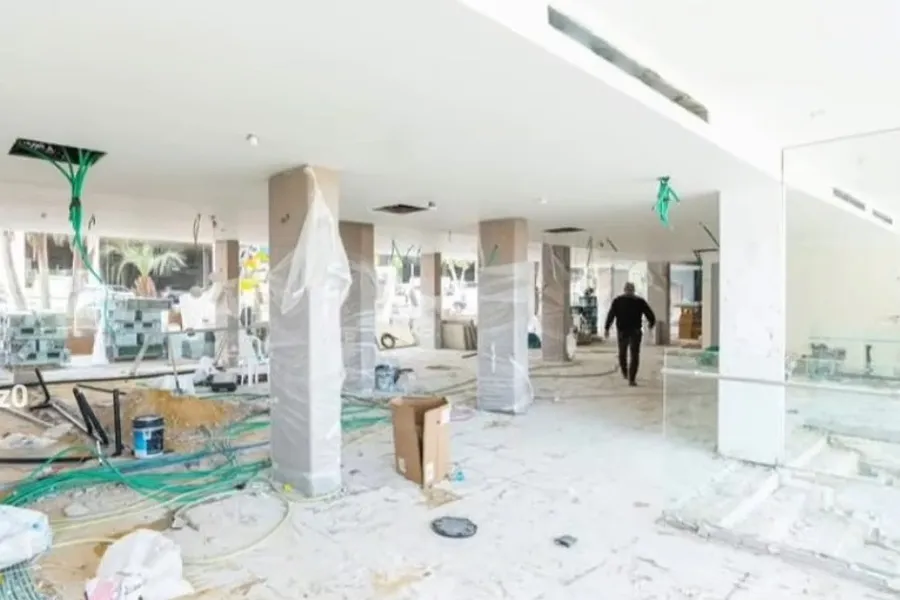 הלובי בשלב ההריסה והשלד: עמודים חשופים, רצפה מפורקת ופסולת בנייה