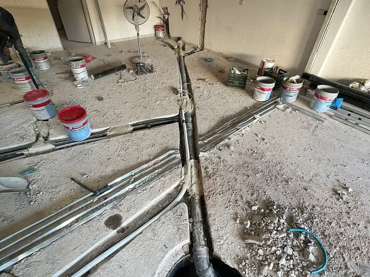 צנרת מים וביוב חדשה מונחת ברצפת בטון לפני יציקה