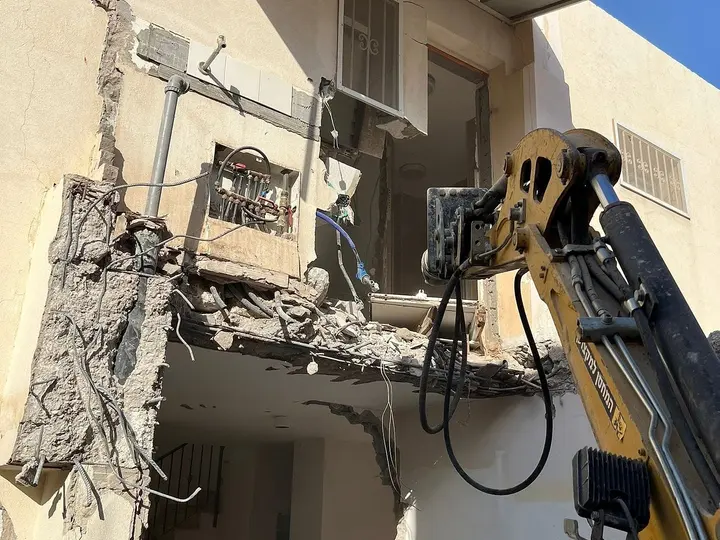 מחפרון מפרק מרפסת בטון בעבודות הריסה בבית פרטי